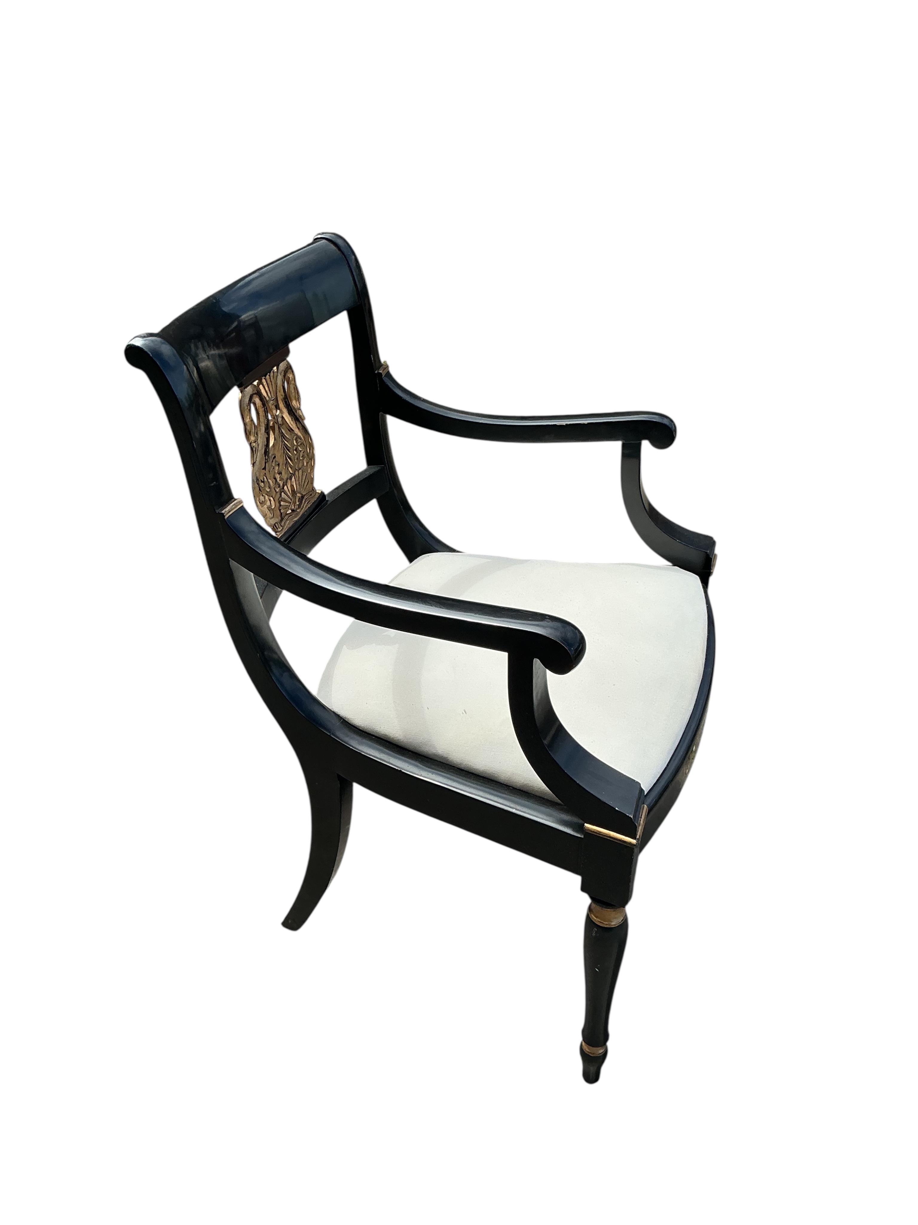 A set of six Empire style ebonised parcel gilt dining chairs, two with arms